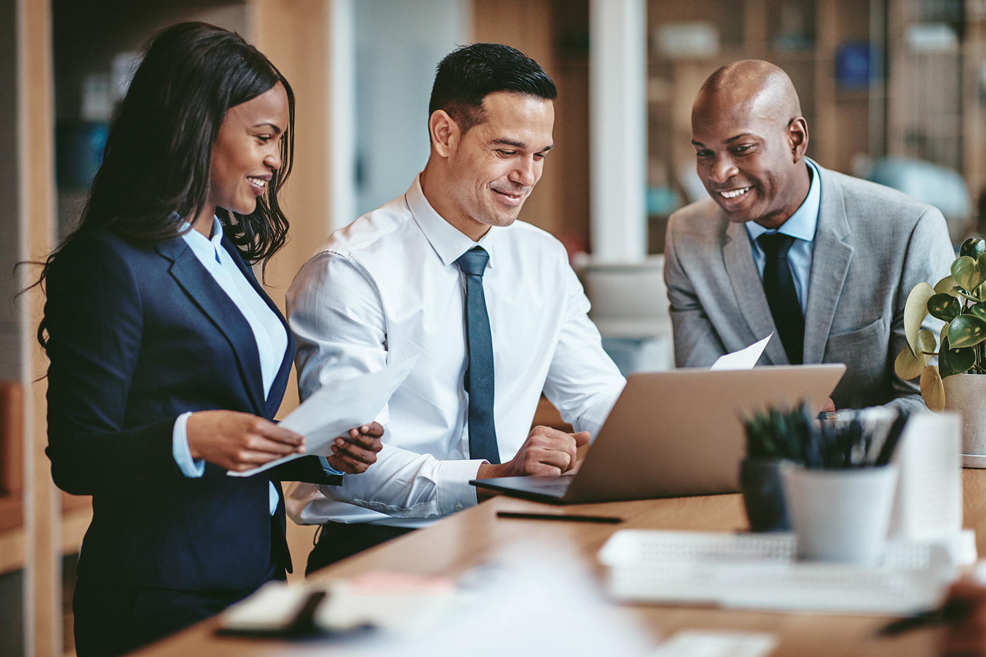 Smiling group of diverse businesspeople going over paperwork